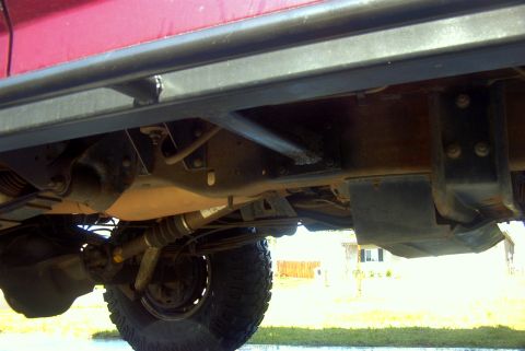 1994 Ford Bronco - Close-up view of the undercarriage and side sliders of a red vehicle.