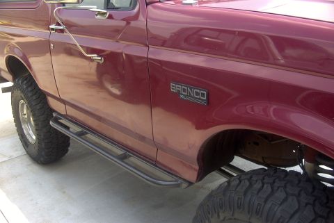 1994 Ford Bronco - This maroon Ford Bronco XL features aftermarket side steps and off-road tires.