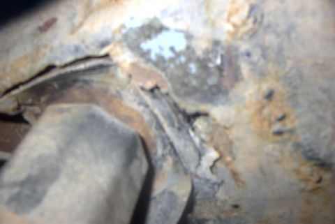 1994 Ford Bronco - Detail of a corroded vehicle frame, showing significant rust and structural damage.