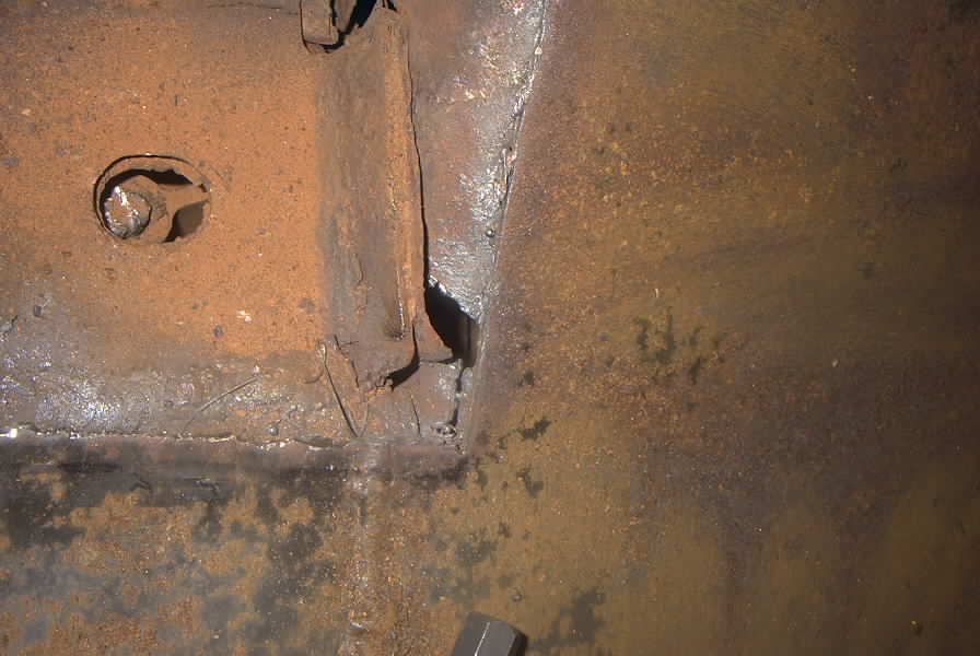 rusted metal frame section with a bolt head visible