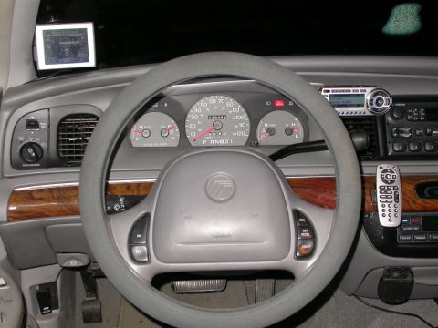 1998 Mercury Grand Marquis - The interior of a 1998 Mercury Grand Marquis shows the dashboard, steering wheel, and center console with aftermarket radio.