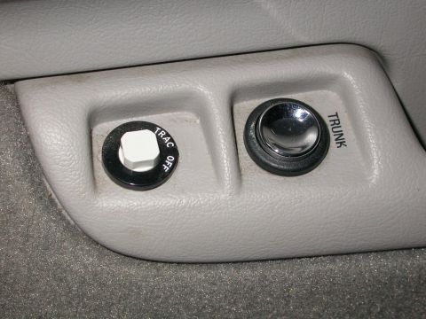 1998 Mercury Grand Marquis - Interior view of two buttons: one for traction control and another for the trunk release.