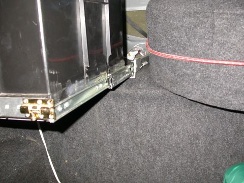 1998 Mercury Grand Marquis - The drawer slide mechanism in the trunk is visible, attached to a black box and carpeted interior.