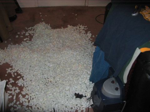 1991 Ford Bronco - A large quantity of packing peanuts covers the floor, obscuring any potential vehicles or details.