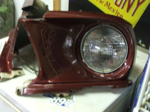1965 Ford Mustang - This is a red fender with a headlight, likely from a 1965 Ford Mustang.