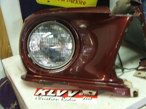 1965 Ford Mustang - This is a 1965 Ford Mustang headlight assembly, showing the red painted housing and the round headlight.
