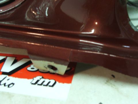 1965 Ford Mustang - A close-up view of a car part reveals a chipped area on its surface, with some text visible beneath.