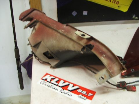 1965 Ford Mustang - A car part with wiring and stickers sits on a table next to a fishing rod.