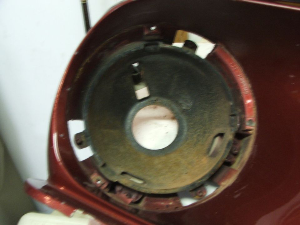 Red car headlight mounting bucket with rust and mounting holes