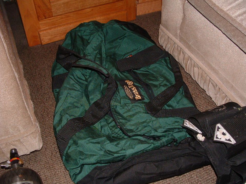 Green duffel bag with "Brass Eagle" logo and a paintball tank on the floor