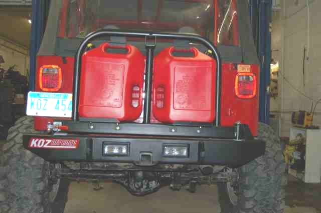 Rear view of red Jeep with two red jerrycans and KOZ Offroad bumper
