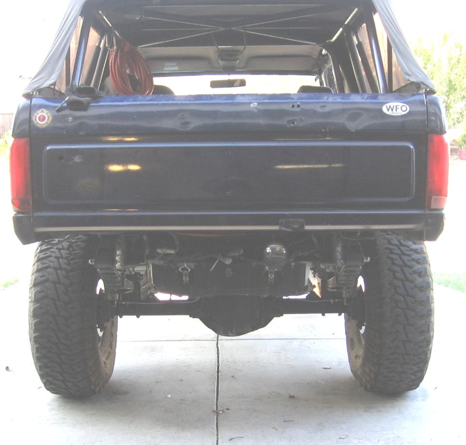 Rear view of a dark blue Ford Bronco with aftermarket suspension and large tires