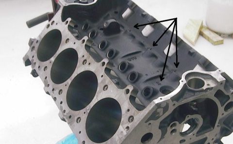 1990 Ford Mustang - Close-up of an engine block, showing cylinder bores and internal passages indicated by arrows.