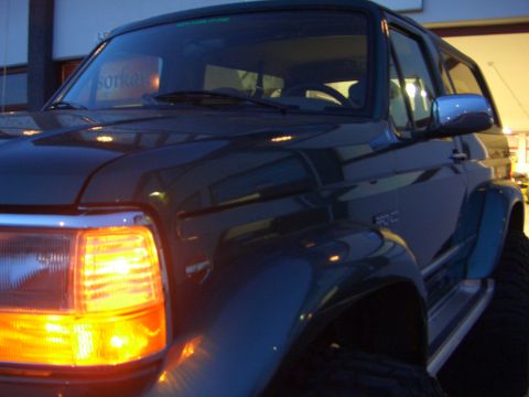 1996 Ford Bronco - This Ford Bronco is shown from the front passenger side with its headlight illuminated.