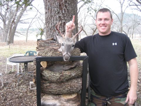 1986 Ford Bronco - A man poses with a mounted deer head, which has a finger pointing upwards from behind it.
