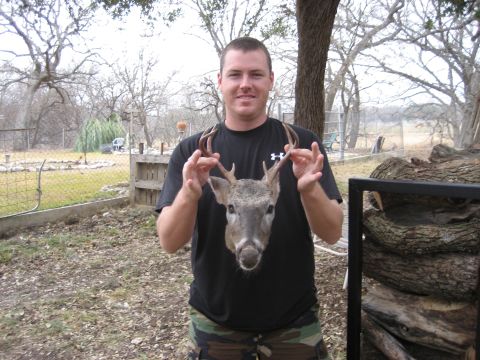 1986 Ford Bronco - Man displays a mounted deer head he is holding up in front of him.