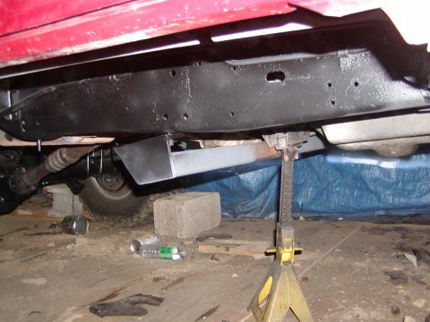 1991 Ford Bronco - The vehicle's frame and undercarriage are visible, supported by jack stands in a garage setting.