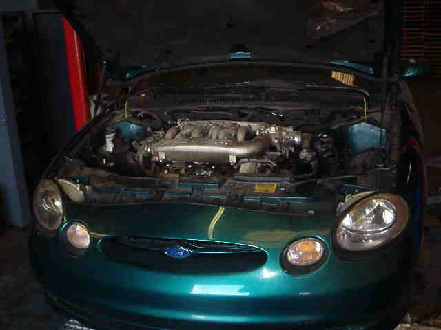 Green 1997 Ford Taurus engine bay with hood open
