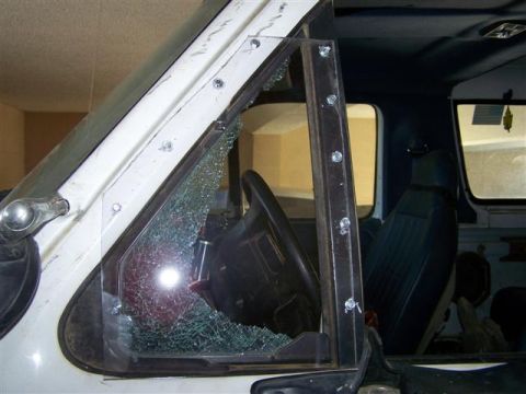 1995 Ford Bronco - The interior of a 1995 Ford Bronco shows a shattered driver's side window, revealing the steering wheel and dashboard.