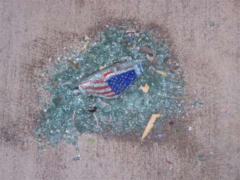1995 Ford Bronco - Shattered glass and a piece of the American flag lie on a concrete surface.