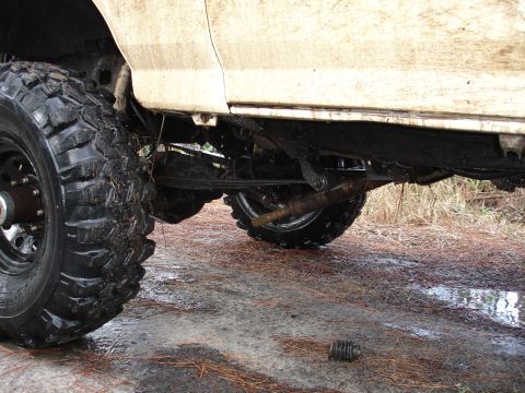 1989 Ford Bronco - The undercarriage of a lifted 1989 Ford Bronco, equipped with large off-road tires, is shown in this side view.