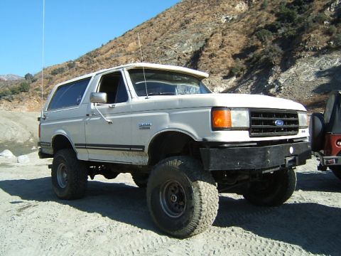 1988 Ford Bronco - This 1988 Ford Bronco, identified by its body style, is shown in a three-quarter front view with prominent off-road tires.