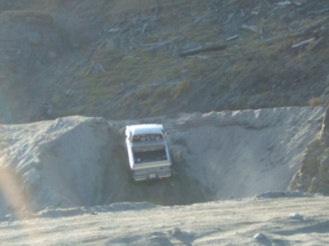 Silver pickup truck navigating a sandy incline