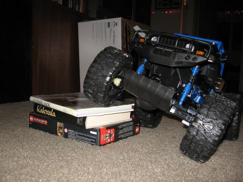 1990 Ford Bronco - A blue toy truck is balanced on a stack of books.