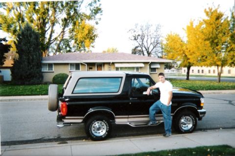 1996 Ford Bronco - A man poses with his black and tan 1996 Ford Bronco parked in front of a house.