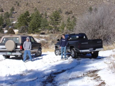 1996 Ford Bronco - Two men stand by their vehicles, a Ford Bronco and a Dodge Ram, in a snowy, wooded area.