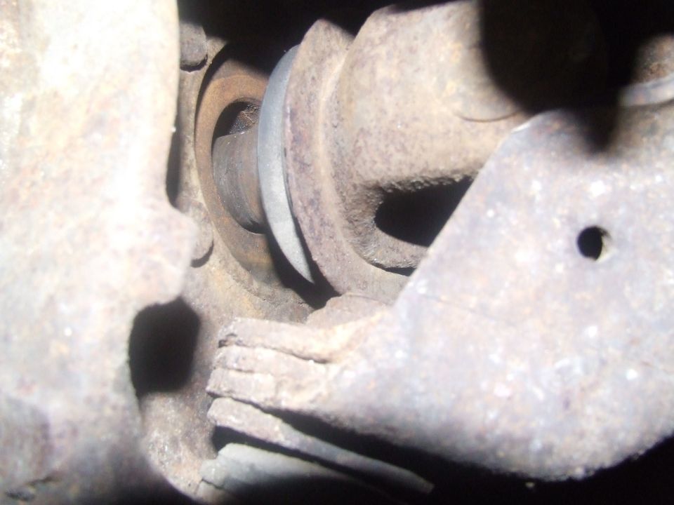 Close-up of rusty suspension part with a metal band