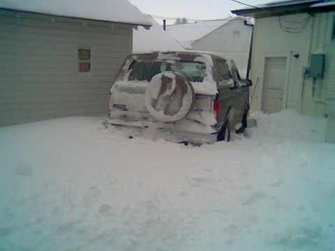 1996 Ford Bronco - A 1992 Ford Bronco is partially buried in snow, showing its rear end and spare tire.