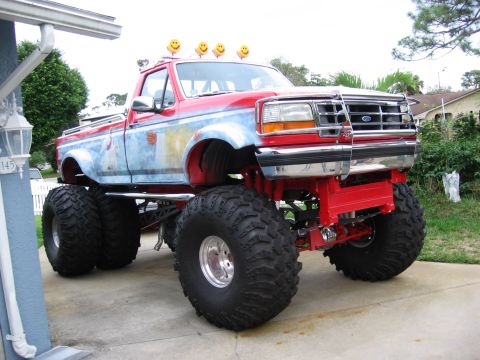 1974 Ford F-100 - This lifted pickup truck features large off-road tires and decorative smiley face lights on its roof.