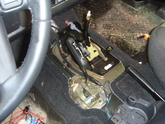 Vehicle interior showing center console with exposed transmission shifter and wiring