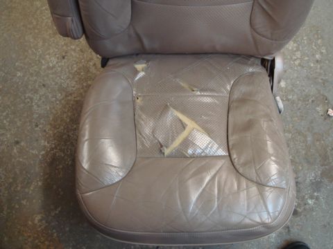 1996 Ford Bronco - This car seat has significant damage to its upholstery, revealing the underlying foam.