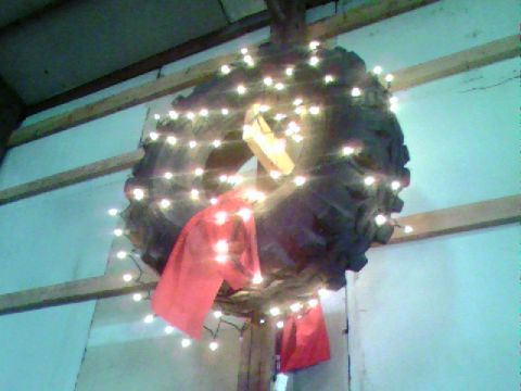 1976 GMC C/K Pickup - A tire transformed into a holiday wreath, adorned with festive lights and bows.