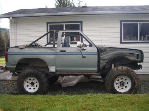 1984 Ford Bronco II - This 1984 Ford Bronco II is parked in front of a house, showing its side profile and custom roll cage.