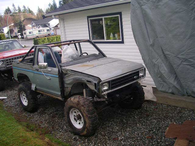 1984 Ford Bronco II, light blue, 3/4 front view, off-road tires, roll cage
