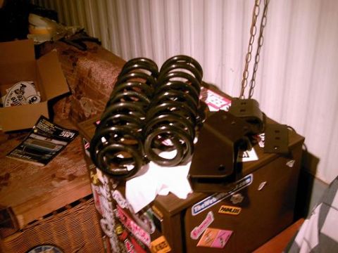 1986 Ford Bronco - Suspension lift components, including coil springs and a bracket, are displayed on a surface.