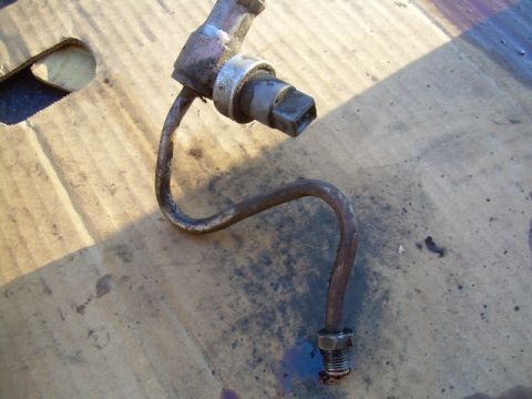 1992 Ford Bronco - Close-up of a detached power steering line and sensor assembly.