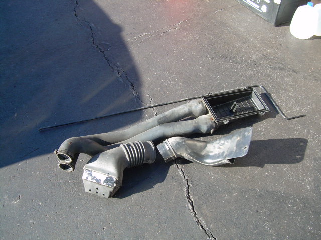 air intake hoses and air filter box on asphalt