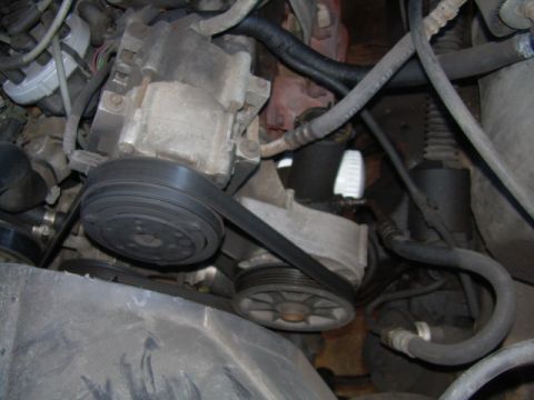 1992 Ford Bronco - Engine compartment detail showing the power steering pump and associated belts and pulleys.