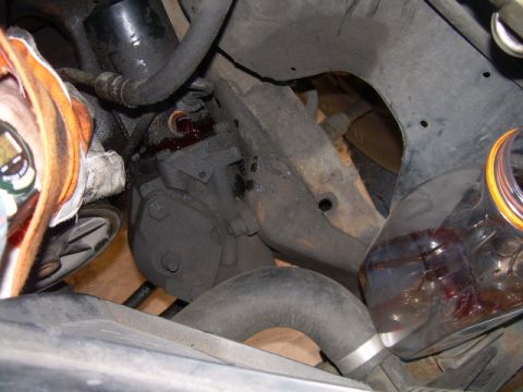 1992 Ford Bronco - A close-up view of a vehicle's power steering pump showing a fluid leak.