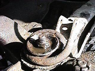 1986 Ford Bronco - A close-up view of a rusty suspension part, a watermark from SuperMotors.net.