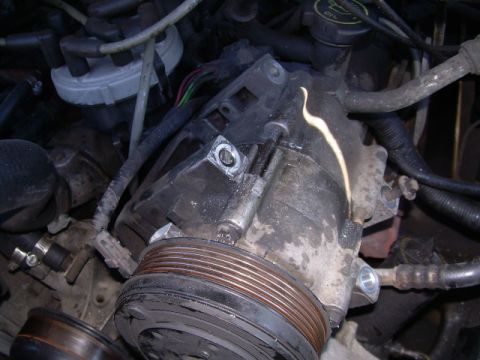 1992 Ford Bronco - Close-up view of a power steering pump, showing its pulley and various hoses.