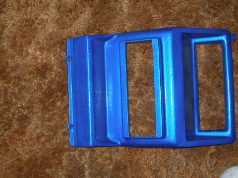 1984 Ford Bronco - This blue dashboard trim piece has two openings for gauges or switches and is shown on a carpeted surface.