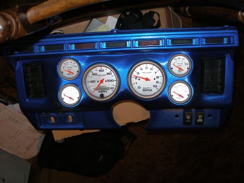 1984 Ford Bronco - A custom blue dashboard assembly several gauges, including speedometer and RPM, along with air vents.