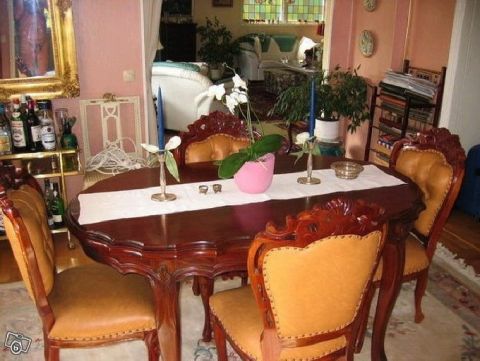 1968 Ford Mustang - Interior scene of a dining room a wooden table, upholstered chairs, and decorative elements.