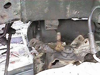 1986 Ford Bronco - Close-up of a rusty front suspension component, with a watermark from SUPERMOTORS.NET.