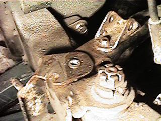 1986 Ford Bronco - This image shows a close-up view of heavily rusted suspension parts, with a watermark from Supermotors.net visible.